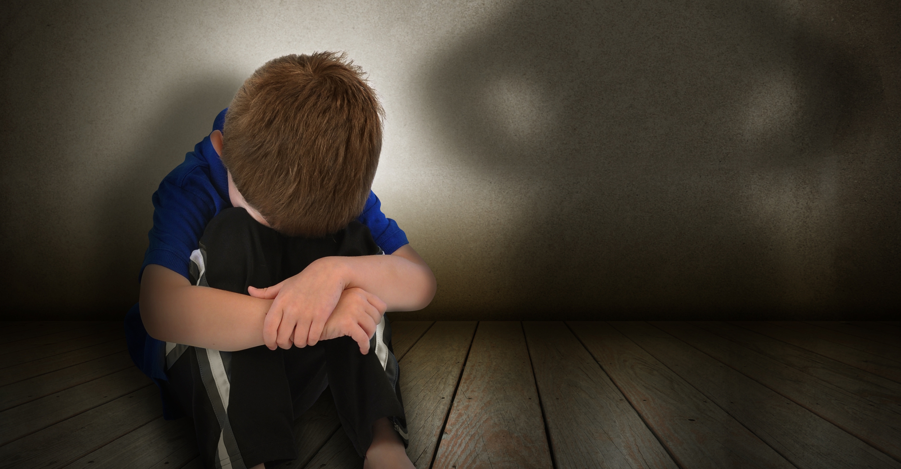 Boy resting head scared of parental figure