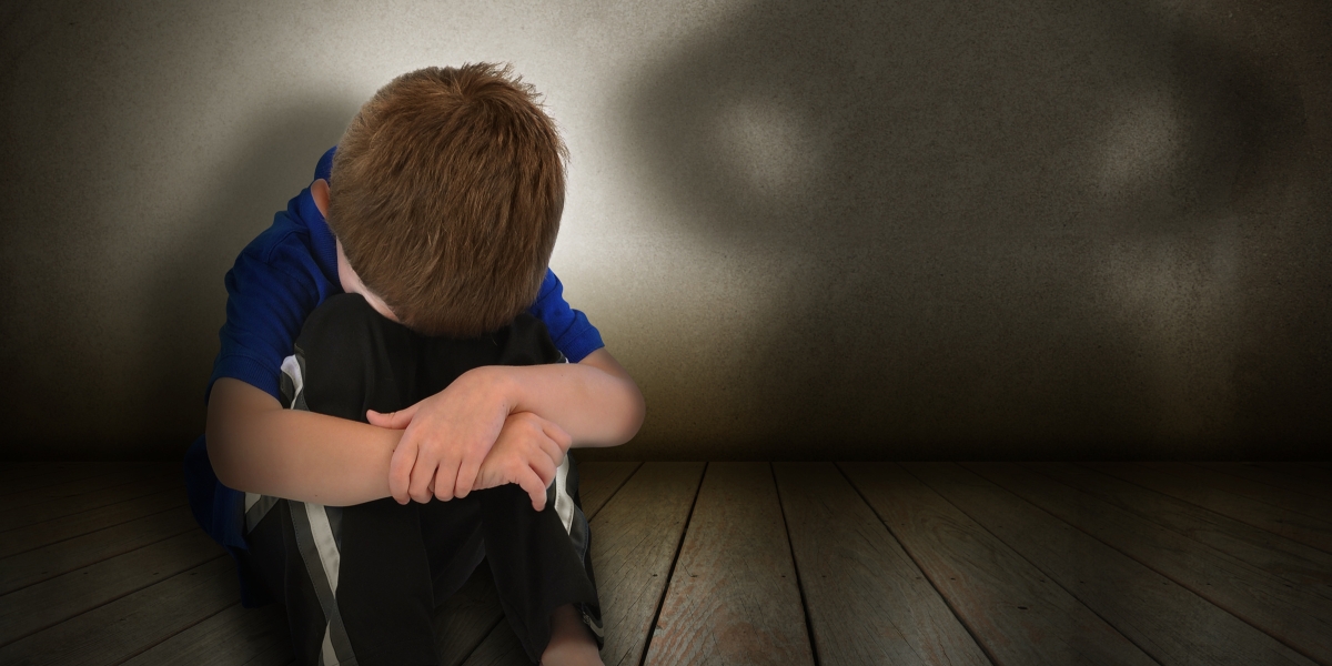 Boy resting head scared of parental figure