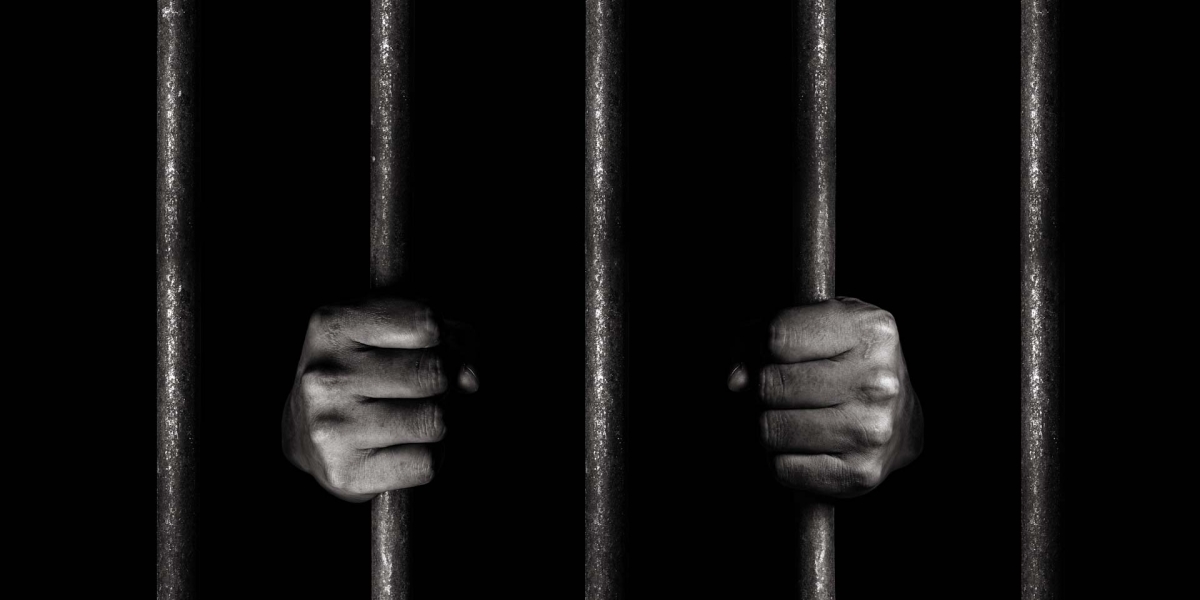 hands holding prison bars